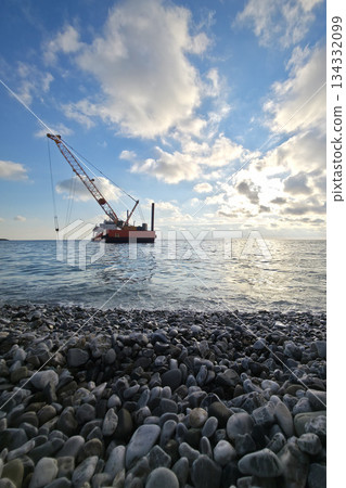 a dredge with crane dredging the sea bottom near the shore a dredge with crane dredging the sea bottom near the shore 134332099