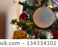 White ball with shimmer on the branches of a Christmas tree 134334102