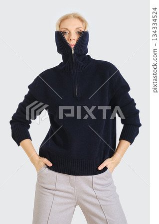Stylish dark sweater worn by a model in a minimalistic setting during a fashion photoshoot 134334524