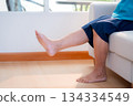 Close up leg senior woman practice stretch leg for treatment knee pain sitting on sofa. 134334549