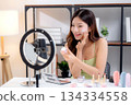 Young asian woman presenting and review cosmetic product with excitement on social media. 134334558