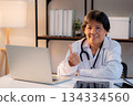 Portrait senior asian doctor woman working on laptop computer on desk in clinic. 134334560