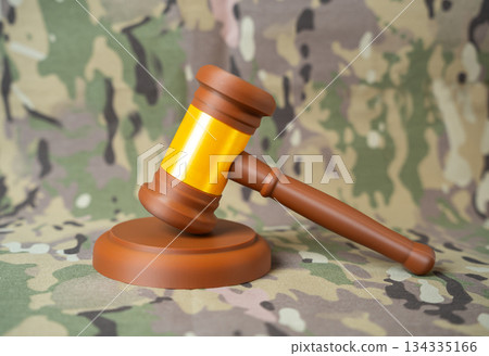 Judge's gavel against a military background. Legislation and law in the military sphere. Tribunal. Military justice, court proceedings and legal enforcement armed forces regulations and discipline. 134335166