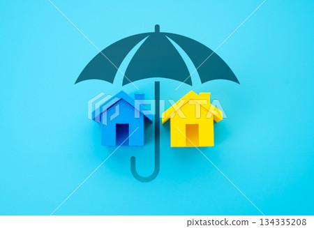 Houses in the colors of the Ukrainian flag under the protection of an umbrella. Support for Ukrainian refugees and displaced persons. Humanitarian aid, housing security and social solidarity Houses in the colors of the Ukrainian flag under the protection of an umbrella. Support for Ukrainian refugees and displaced persons. Humanitarian aid, housing security and social solidarity 134335208