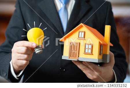 A light bulb and a private home. Energy supply and building autonomy. Smart home. Renovation. Energy efficiency solutions support independence, sustainability and modern housing upgrades. 134335232
