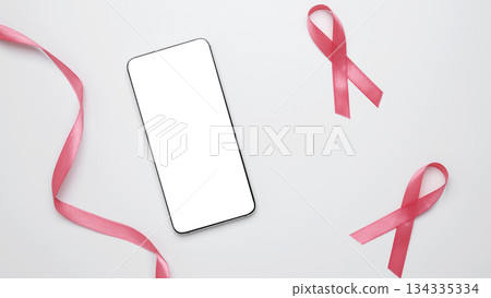 Pink ribbon on smartphone mockup for prevention reminders. Breast cancer awareness 134335334