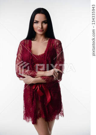 Elegant woman in red lingerie poses gracefully in a studio setting Elegant woman in red lingerie poses gracefully in a studio setting 134335943