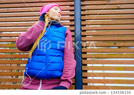 Woman wearing warm sportswear relaxing after exercising 134336150