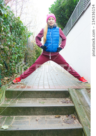 Woman wearing sportswear exercising outside during autumn Woman wearing sportswear exercising outside during autumn 134336154
