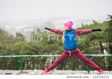 Woman wearing sportswear exercising outside during autumn Woman wearing sportswear exercising outside during autumn 134336155