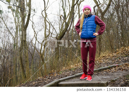 Woman wearing sportswear exercising outside during autumn Woman wearing sportswear exercising outside during autumn 134336158