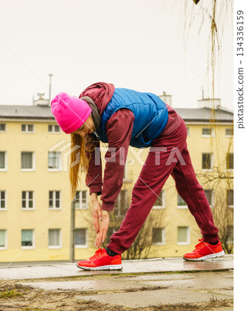 Sporty girl stretching outdoor on city street. Sporty girl stretching outdoor on city street. 134336159