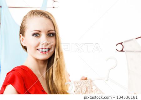 Woman in shop or wardrobe picking dress Woman in shop or wardrobe picking dress 134336161