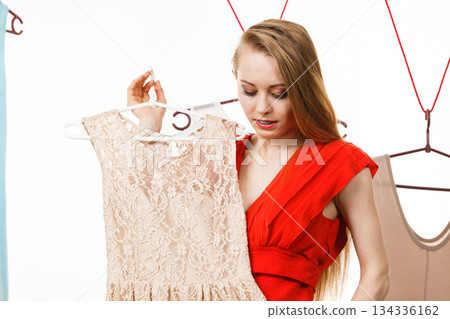 Woman in shop or wardrobe picking dress Woman in shop or wardrobe picking dress 134336162