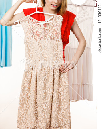 Woman in shop or wardrobe picking dress Woman in shop or wardrobe picking dress 134336163