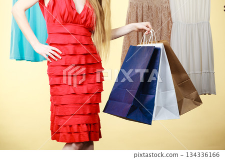 Woman wearing dress holding shopping bags 134336166