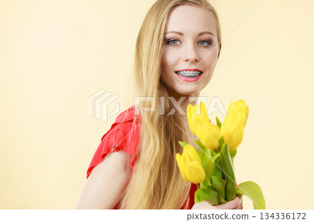 Pretty woman with yellow tulips bunch 134336172
