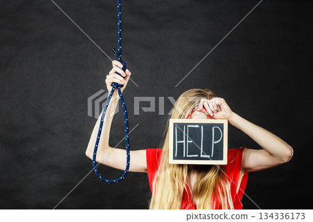 Suicidal woman holding help sign next to rope 134336173