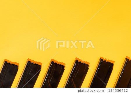 Black RAM modules along bottom edge on yellow background, copy space Black RAM modules along bottom edge on yellow background, copy space 134336412