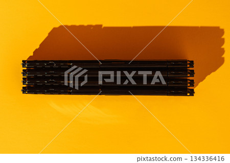 Four black RAM modules stacked horizontally on yellow background 134336416