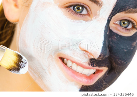 Girl black mask on half face apply white mud Girl black mask on half face apply white mud 134336446
