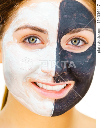 Girl black mask on half face apply white mud Girl black mask on half face apply white mud 134336447