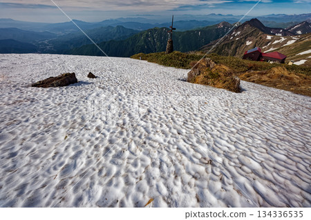 Snowfield just below the summit of Mt. Tanigawa, the hut on the shoulder, and the mountain range of Joshu Snowfield just below the summit of Mt. Tanigawa, the hut on the shoulder, and the mountain range of Joshu 134336535