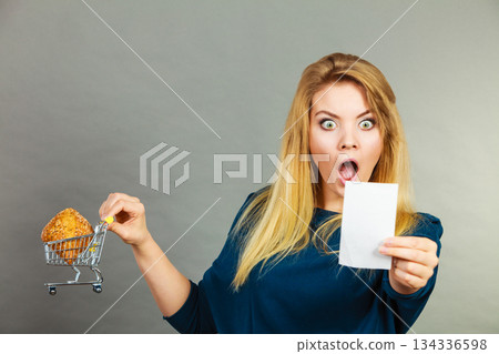 Shocked woman holding shopping basket with bread 134336598
