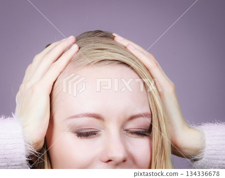 Happy blonde woman holding head out of joy Happy blonde woman holding head out of joy 134336678