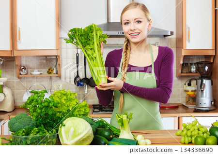 Woman in kitchen with green vegetables 134336690
