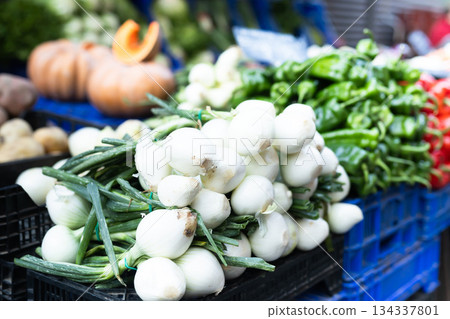 Pile of onions displayed on market counter 134337801
