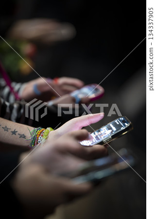 Hands using smartphones during a social event at night 134337905