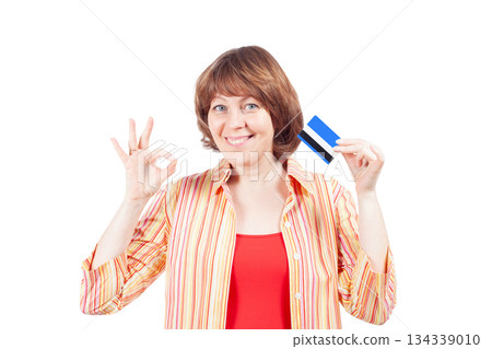 Happy woman holding credit card and showing ok sign on white background 134339010
