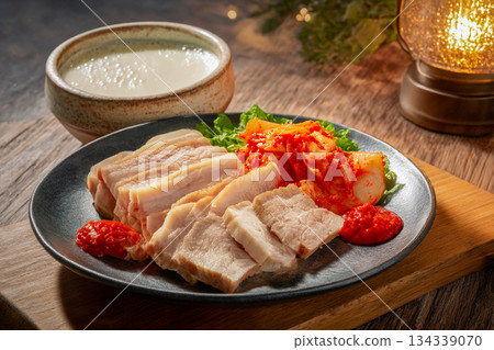 Traditional Korean Kimchi and Suyuk Pork Slices Served Together on a Rustic Plate for Authentic Winter Dining Experience 134339070