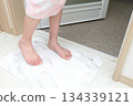A girl wiping her feet on a diatomaceous earth bath mat 134339121