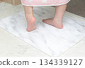A girl wiping her feet on a diatomaceous earth bath mat 134339127
