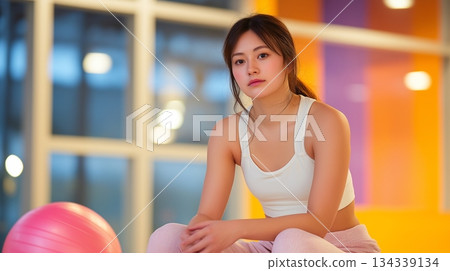 一名女子在健身房的平衡球上進行訓練。 134339134