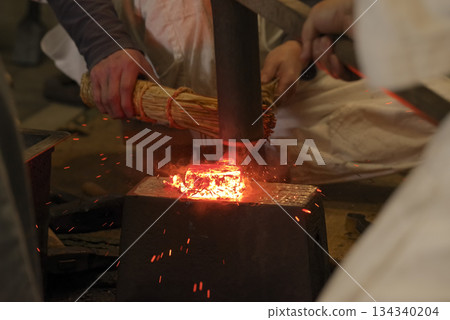 A Japanese blacksmith forging red-hot iron using traditional techniques 134340204