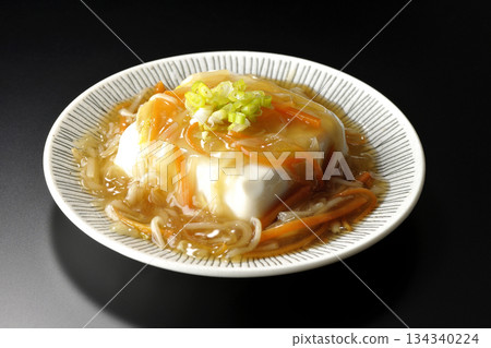Silken tofu with thick bean paste photographed against a black background 134340224