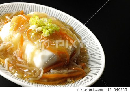 Silken tofu with thick bean paste photographed against a black background 134340235