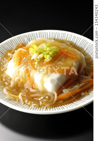 Silken tofu with thick bean paste photographed against a black background Silken tofu with thick bean paste photographed against a black background 134340243