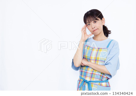 A housewife holding her head in worry 134340424