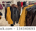 Leather and suede jackets displayed on rack inside modern fashion store interior 134340693