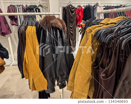Leather and suede jackets displayed on rack inside modern fashion store interior Leather and suede jackets displayed on rack inside modern fashion store interior 134340693