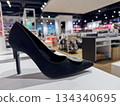 Elegant black high heel shoe with decorative detail displayed in modern fashion store 134340695
