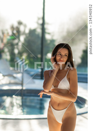Cute slim beautiful young woman in white bikini in spa center Cute slim beautiful young woman in white bikini in spa center 134340952