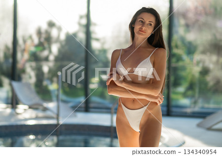 Cute slim beautiful young woman in white bikini in spa center Cute slim beautiful young woman in white bikini in spa center 134340954
