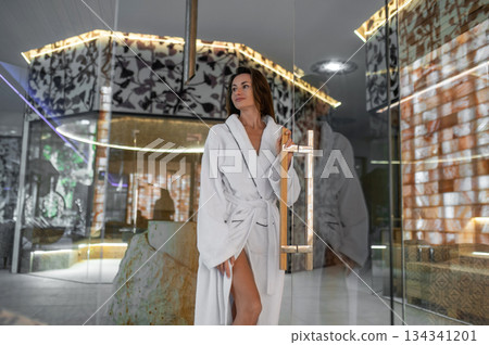 Pretty woman in white bath robe feeling relaxed and peaceful after spa procedures 134341201