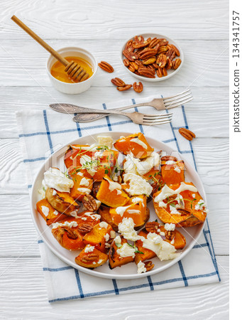 baked butternut squash with cheese, thyme, pecan baked butternut squash with cheese, thyme, pecan 134341757