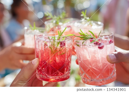 Friends drinking sparkling cocktails. People clinking glasses with drinks outdoors. Close up of hands cheers, making toasts and touch with wineglasses at garden party. Warm Summer Evening. Enjoy Life 134341901